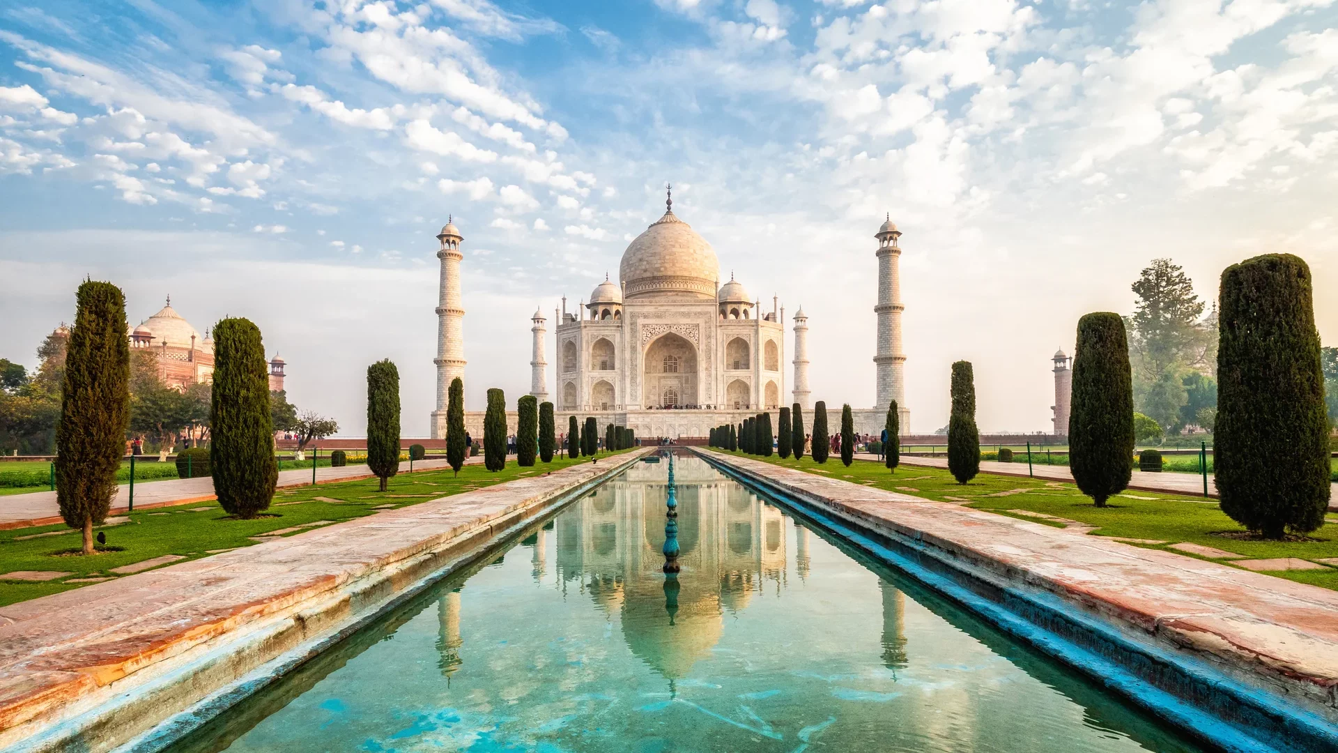 Taj Mahal in Agra mit Spiegelung im Wasserbecken bei Sonnenaufgang