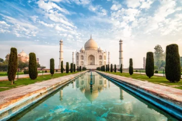 Taj Mahal in Agra mit Spiegelung im Wasserbecken bei Sonnenaufgang