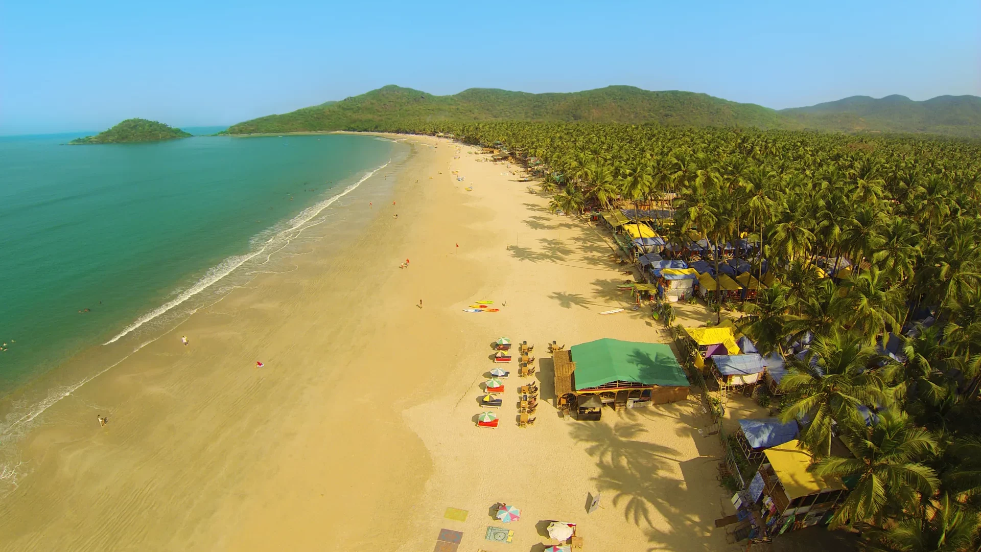 Luftaufnahme der geschwungenen Bucht von Palolem mit Sandstrand und Palmen in Goa