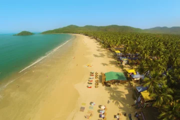 Luftaufnahme der geschwungenen Bucht von Palolem mit Sandstrand und Palmen in Goa