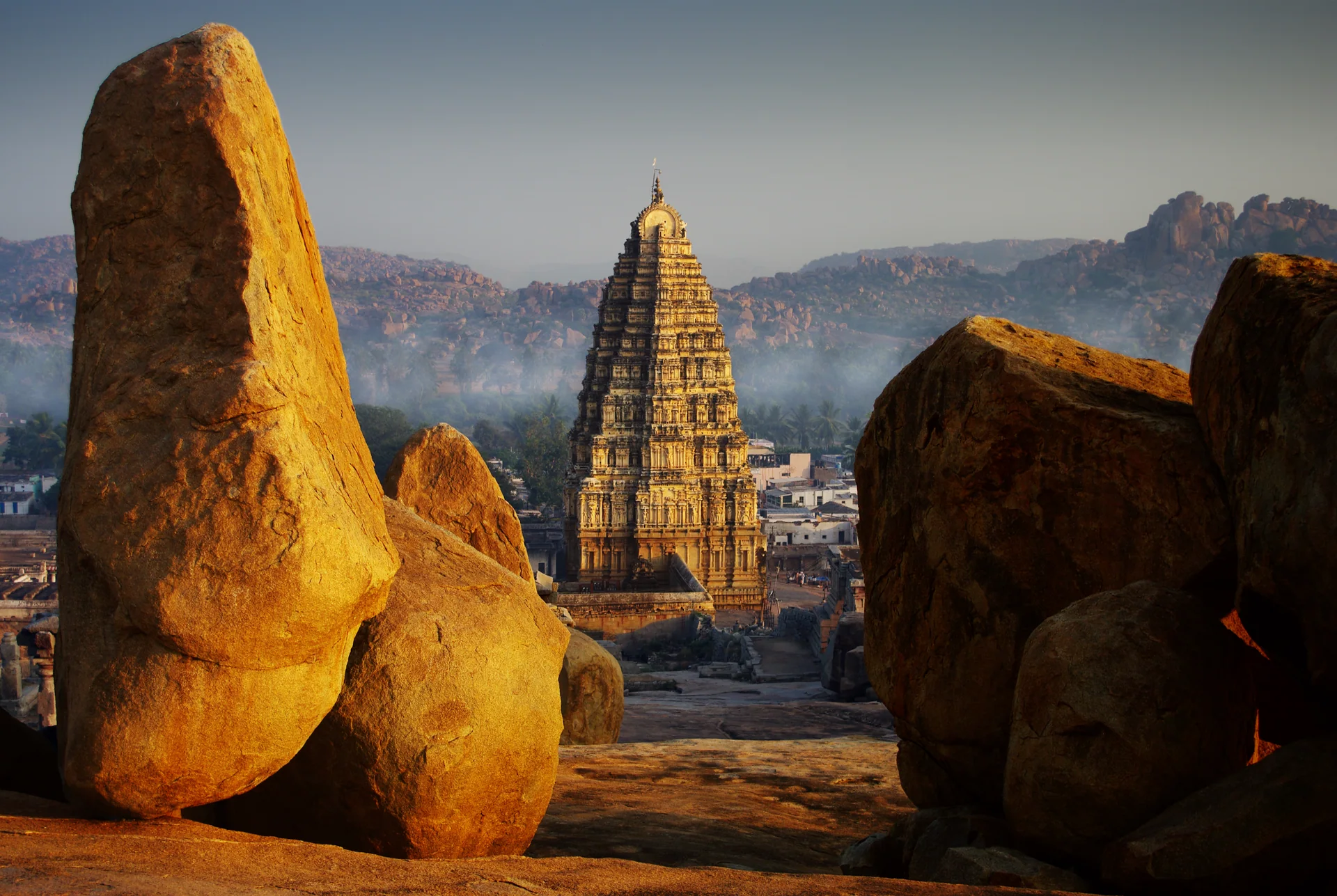 Tempelturm zwischen großen Felsen in Hampi im Abendlicht