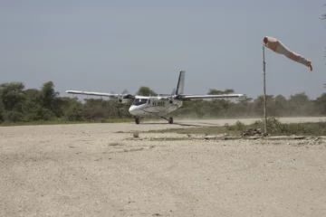 Kleines Propellerflugzeug auf einer unbefestigten Landebahn in der Serengeti